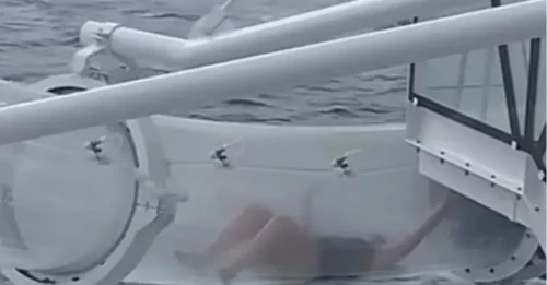 Aterrador momento en que un pasajero de crucero queda atrapado en un tobogán de agua colgando por la borda sobre el mar.