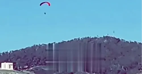 Momento impactante: un migrante se lanza a los cielos para volar en parapente hacia Europa sobre una frontera fuertemente fortificada.